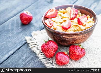 Fresh homemade muesli, muesli with strawberries in a plate on a dark gray background, selective focus, copy space. Fresh homemade muesli, muesli with strawberries in a plate on a dark gray background, selective focus