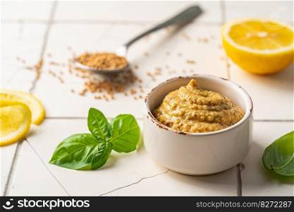 Fresh homemade organic dijon mustard in a bowl on white background, close up. Fresh organic mustard