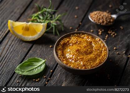 Fresh homemade organic dijon mustard in a bowl on wooden background, close up. Fresh organic mustard