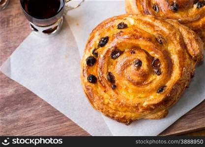 Fresh homemade pain au raisins over wooden background, top view
