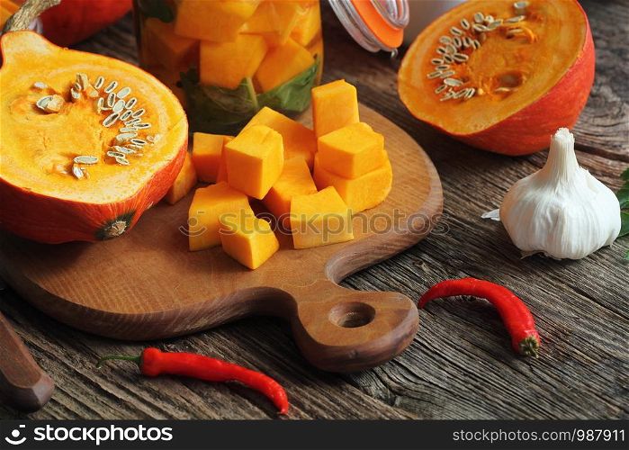 Fresh homemade Pumpkin pickle in a glass and herbs on a wooden table.. Fresh homemade Pumpkin pickle in a glass and herbs on a wooden table