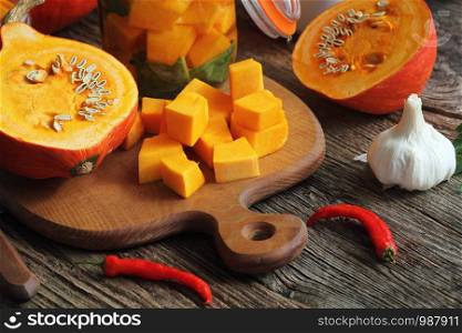 Fresh homemade Pumpkin pickle in a glass and herbs on a wooden table.. Fresh homemade Pumpkin pickle in a glass and herbs on a wooden table