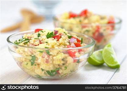 Fresh homemade Tabbouleh, an Arabian vegetarian salad made of couscous, tomato, cucumber, onion, garlic, parsley and lemon juice served in a glass bowl (Selective Focus, Focus one third into the tabbouleh). Fresh Homemade Tabbouleh, an Arabian Salad with Couscous
