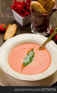 fresh homemade tomato soup with bay leaf on wooden table