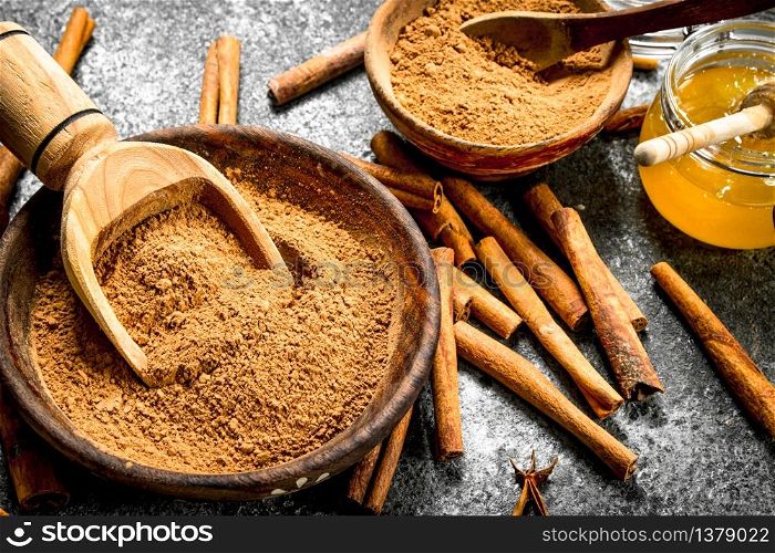 Fresh honey with ground cinnamon in a bowl. On rustic background .. Fresh honey with ground cinnamon in a bowl.