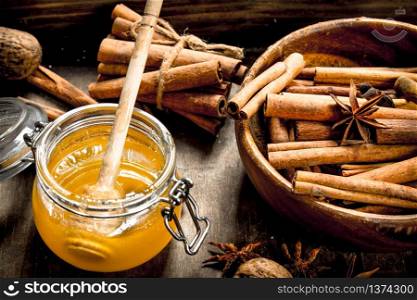 Fresh honey with the cinnamon sticks in a bowl . On rustic background .. Fresh honey with the cinnamon sticks in a bowl .