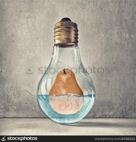 Fresh idea. Glass light bulb and pear in water inside