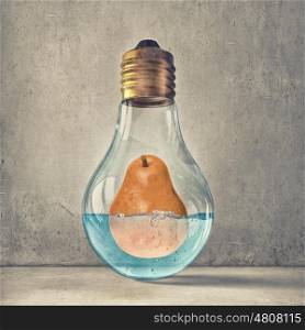 Fresh idea. Glass light bulb and pear in water inside