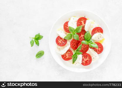 Fresh italian Caprese salad on white plate, view from above