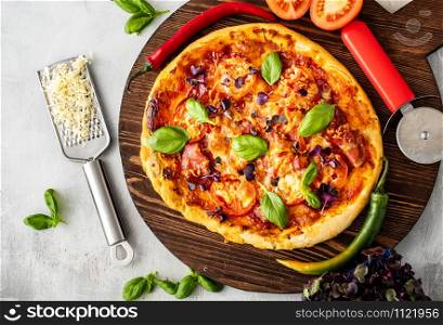 Fresh Italian pizza with bacon, tomato and basil