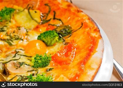 fresh italian thin style vegetarian pizza with fresh mixed vegetables close up