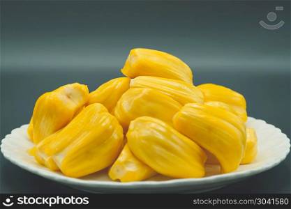 Fresh jackfruit slices on a white plate. sweet yellow jackfruit . Fresh jackfruit slices on a white plate. sweet yellow jackfruit ripe. vegetarian, vegan, raw food. Exotic tropical fruit - isolated