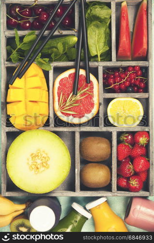 Fresh juices or smoothies with fruits and vegetables in wooden tray on blue background, top view, selective focus. Detox, dieting, clean eating, vegetarian, vegan, fitness, healthy lifestyle concept
