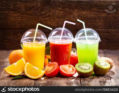 Fresh juices with fruits and vegetables on wooden background