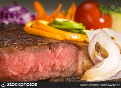 fresh juicy beef ribeye steak sliced ,with lemon and orange peel on top and vegetable beside