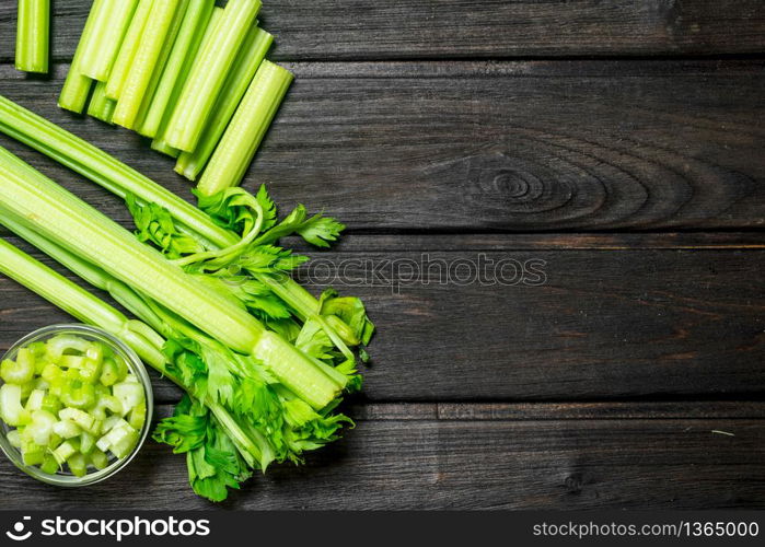 Fresh juicy celery in a bowl. On wooden background. Fresh juicy celery in a bowl.