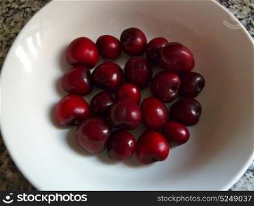 fresh juicy cherries in a white bowl