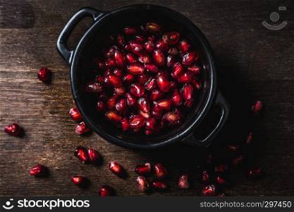 Fresh juicy pomegranate on a wooden vintage background, top view, horizontal, with copy space