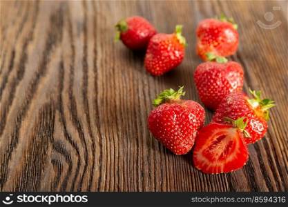 Fresh juicy ripe red strawberry on a brown wooden background