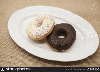 Fresh juicy sweet pastries donuts on a dark background.. Fresh juicy sweet pastries donuts on a dark background