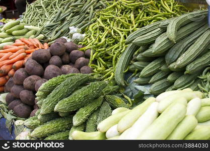 Fresh juicy vegetables, eggplant, cucumber, beans on a counter in the Indian market Goa.