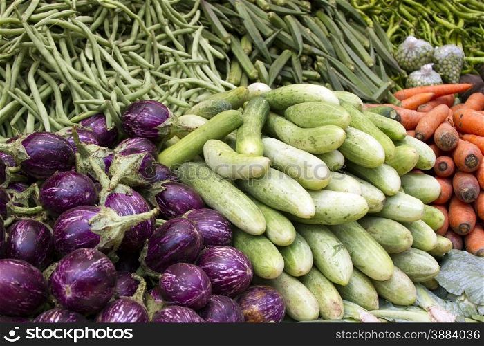 Fresh juicy vegetables, eggplant, cucumber, beans on a counter in the Indian market Goa.