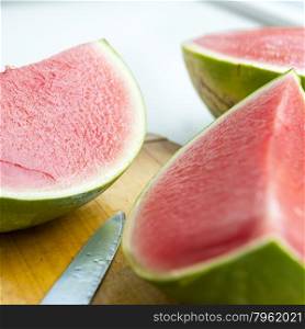 Fresh juicy watermelon sliced on wooden board in shallow focus