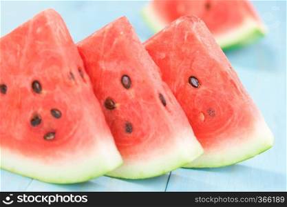 Fresh juicy watermelon slices photographed on blue wood  Selective Focus, Focus on the front of the third melon slice . Fresh Watermelon Slices