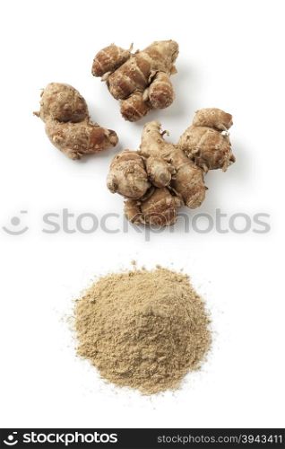 Fresh kencur roots and ground kencur powder on white background