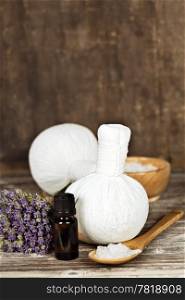 Fresh lavender flowers, salt, essential oii and Herbal massage balls over wooden surface