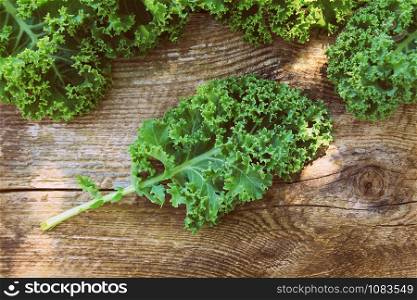 Fresh leaf of kale cabbage on wooden background. Green vegetable leaves. Top view . Healthy eating, vegetarian food .