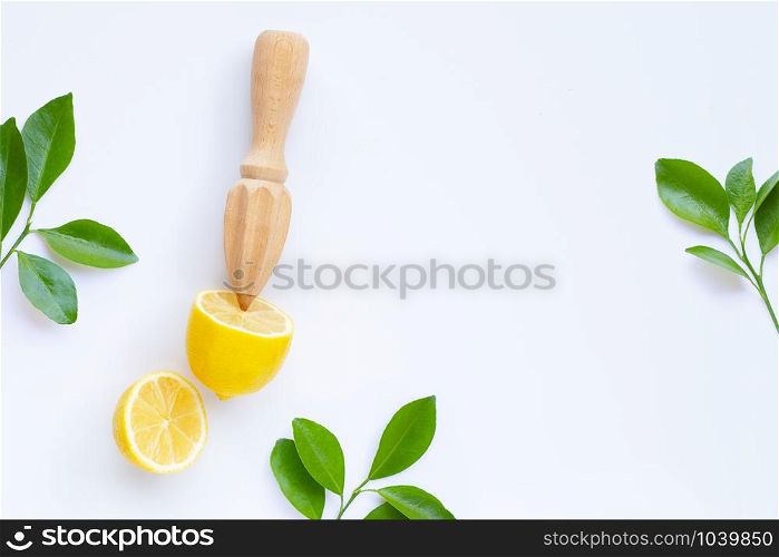 Fresh lemon and leaves with wooden juicer on white background. Copy space
