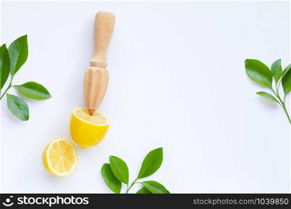 Fresh lemon and leaves with wooden juicer on white background. Copy space