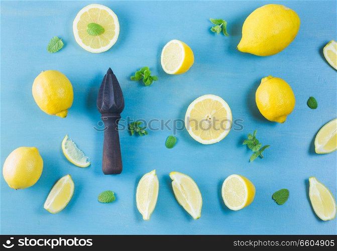 Fresh lemon citrus fruits with citrus reamer on blue bakground. Fresh lemon fruits