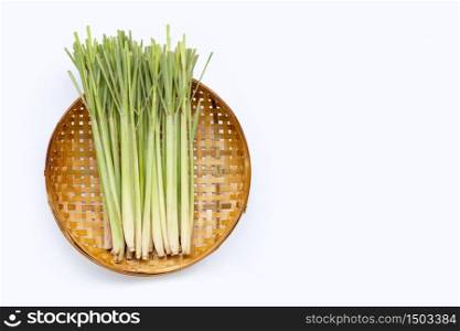 Fresh lemongrass on wooden bamboo threshing basket on white background. Copy space