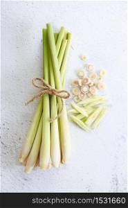 Fresh lemongrass rope and lemongrass slices on white marble background, cooking concept