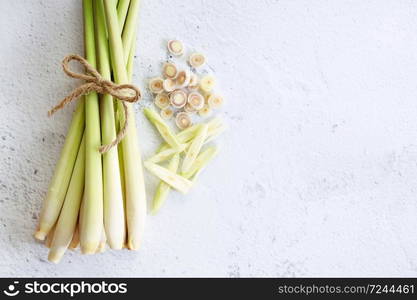 Fresh lemongrass rope and lemongrass slices on white marble background, cooking concept