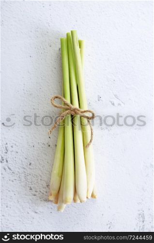 Fresh lemongrass rope on white marble background, top view