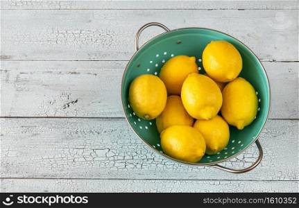 Fresh lemons in the colander  top view