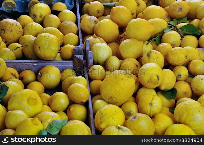 Fresh lemons in wooden crates at grocery store.