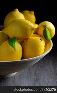 Fresh lemons with leaves in plate