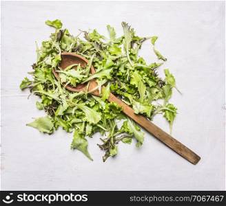 fresh lettuce with a wooden spoon on wooden rustic background top view close up