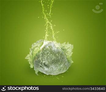 Fresh lettuce with water splashes on green background.