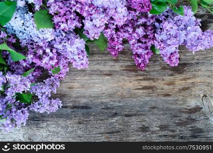Fresh lilac flowers over wooden background with copy space, flat lay floral composition with copy space. Fresh lilac flowers