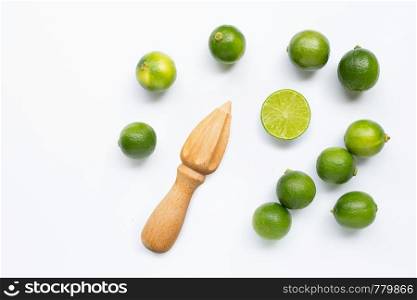 Fresh limes and wooden juicer on white background. Top view