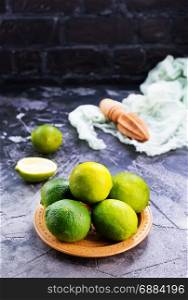 fresh limes on plate and on a table