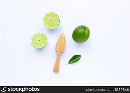 Fresh limes with wooden juicer on white background. Copy space