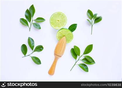 Fresh limes with wooden juicer on white background. Top view