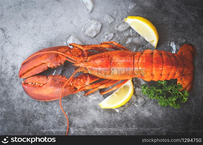 Fresh lobster food on a black plate background / red lobster dinner seafood with herb spices lemon served table and ice in the restaurant gourmet food healthy boiled lobster cooked , top view