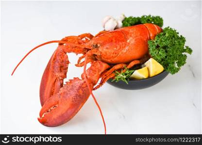 Fresh lobster food on a bowl and white table background / red lobster dinner seafood with herb spices lemon rosemary served table and in the restaurant gourmet food healthy boiled lobster cooked